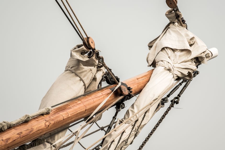 Detailed view of a vintage sailboat's mast and rigging, showcasing classic nautical elements.